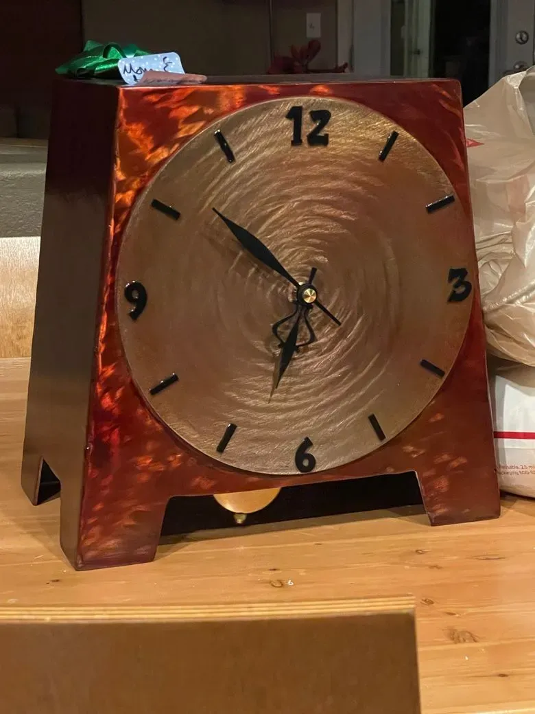 Mantel clock with a burnished red and copper metal finish