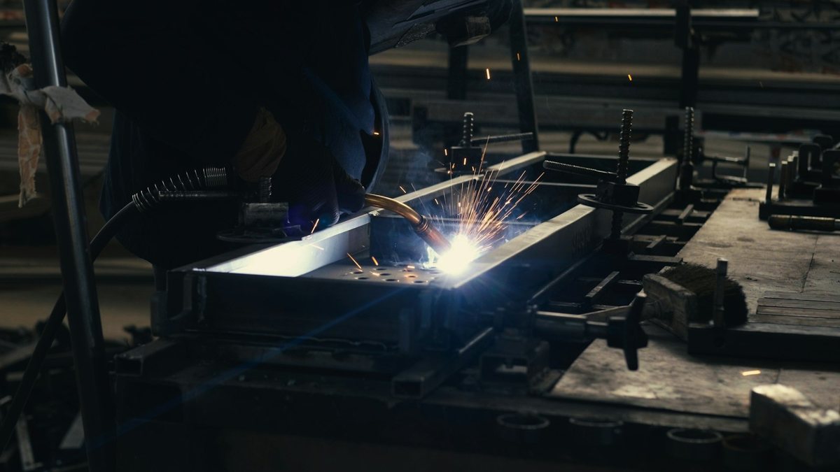 Welder fusing metal components with bright sparks